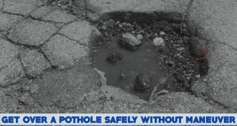 What Should you do to get over a pothole safely if you can’t swerve around it?